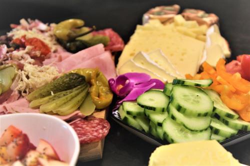 a bunch of different types of cheese and vegetables at Apart Garni Jägerheim in Kappl