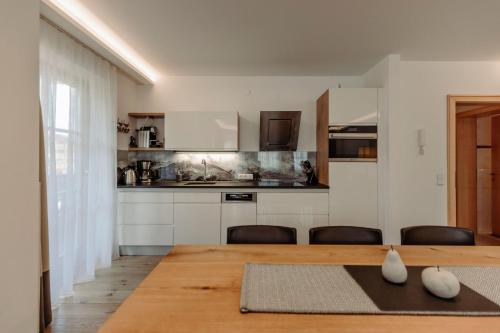 a kitchen with a table and chairs in a room at Ferienwohnungen Renberg in Maria Alm am Steinernen Meer