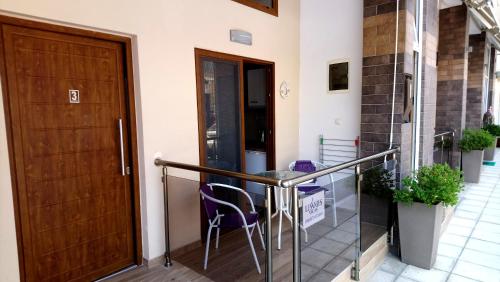a balcony with a wooden door and a table and chairs at Levantes in Asprovalta