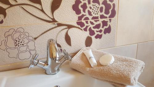 a bathroom sink with a toothbrush holder and a faucet at Caza Blanca Apartments ( La como Lifestyle Estate) in Boksburg
