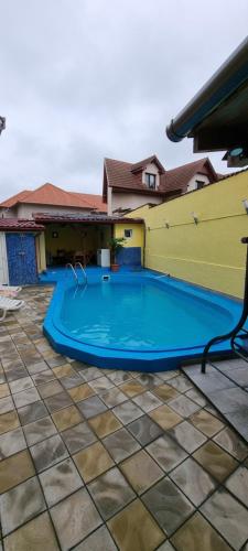 a large blue swimming pool in a yard at Pensiunea Chrisland in Oradea