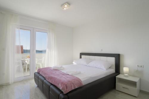 a bedroom with a bed with a view of the ocean at Villa Anđelo in Trogir