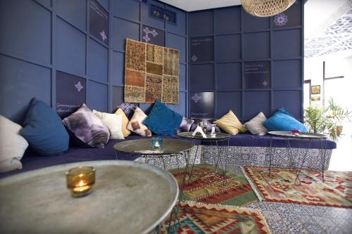 Pokój z niebieską kanapą z poduszkami i stołami w obiekcie Villa Livia Boutique Apartments w Rawdzie