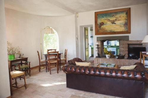 La Casina في Casteggio: غرفة معيشة مع أريكة جلدية بنية وطاولة