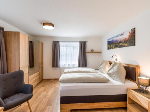 a hotel room with a bed and a chair at Appartement Ortner in Westendorf