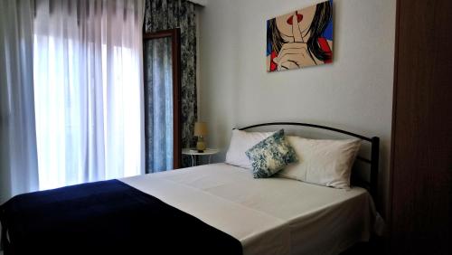 a bedroom with a bed and a window with at Levantes in Asprovalta
