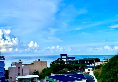 a view of a city with the ocean in the background at Rainbow B&B in Dahan
