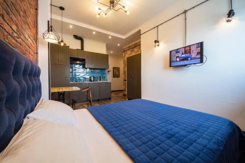 a bedroom with a blue bed and a kitchen at Cheap Apartments in Kyiv
