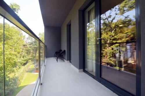 a balcony with sliding glass doors and a view of the yard at Dwie Sosny z sauną, Sun & Snow in Ustronie Morskie