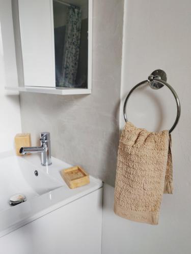 La salle de bains est pourvue d'un lavabo et d'une serviette accrochée au mur. dans l'établissement La maisonnette de Saint Chamas, à Saint-Chamas