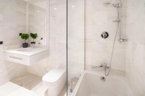 a white bathroom with a toilet and a sink and a shower at The Antwerp Marble Lodge in Antwerp