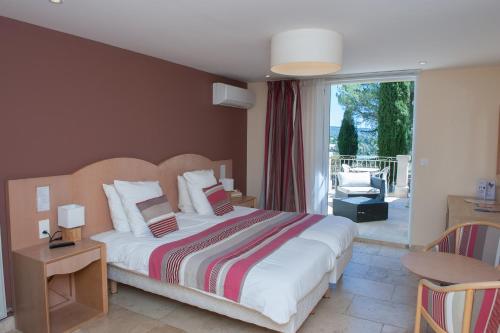 a bedroom with a large bed and a balcony at Mas De La Tour in Gargas