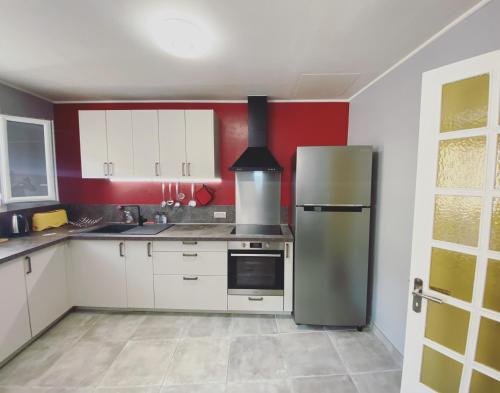 uma cozinha com armários brancos e um frigorífico em La Maison de Rose em Cassis