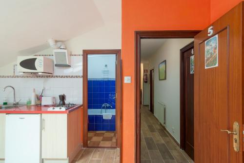 a kitchen with orange walls and a kitchen with a sink at La Casa de Mamasita in Queveda