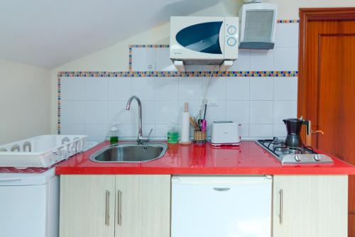 a kitchen with a red counter top and a sink at La Casa de Mamasita in Queveda