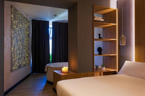 a bedroom with a bed and a window with a tub at Hospedium H Cabo Sport in Finisterre