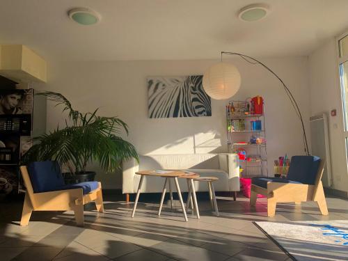 a living room with chairs and a table and a couch at Résid'Artel Cadarache - ITER in Saint-Paul-lez-Durance