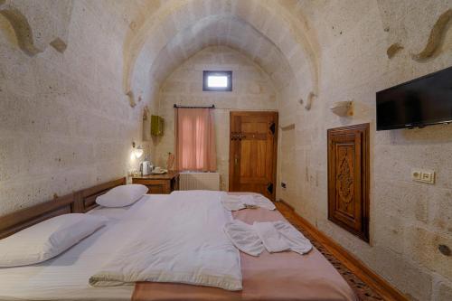 a bedroom with a large bed in a stone wall at Yoruk Stone House in Nevsehir