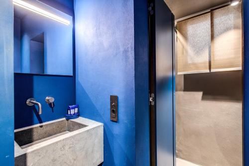 a blue bathroom with a sink and a shower at Elysium Suites collection in Rome