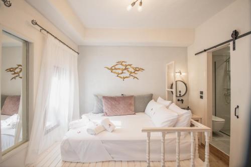 Dormitorio blanco con cama blanca y almohadas rosas en Bastion Luxury Medieval Accommodation, en Rodas