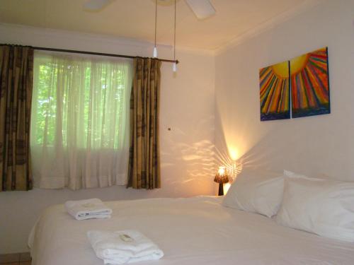 1 dormitorio con 1 cama con 2 toallas en Louhallas Accommodation, en Edenvale