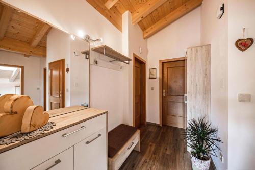 a kitchen with white cabinets and wooden ceilings at Panoramawohnung Annaheim in Rifiano