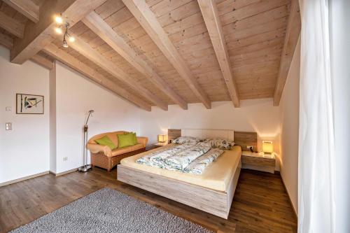 a bedroom with a large bed and wooden ceilings at Panoramawohnung Annaheim in Rifiano