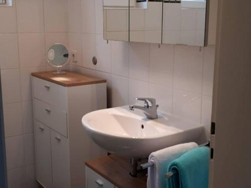 ein Badezimmer mit einem Waschbecken, einem Spiegel und Handtüchern in der Unterkunft Haus Marianne Schmelzle in Freudenstadt