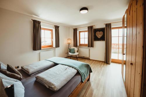 una camera con due letti e una sedia e finestre di Apartment Andreas - Gallhof a Vollan