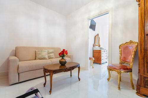 a living room with a couch and a table and a chair at Villa Eleonora Paestum in Paestum