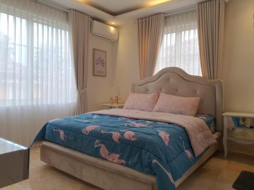 a bedroom with a large bed with pink flamingos on it at Omah Kumpul Sentul in Bogor