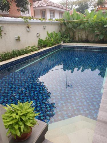 a swimming pool with blue tiles on the side of a house at Omah Kumpul Sentul in Bogor
