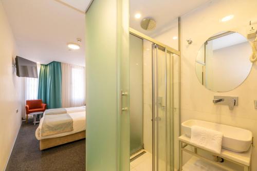 a bathroom with a shower and a sink and a mirror at Taksim Hotel V Plus in Istanbul