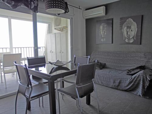 een woonkamer met een tafel en stoelen en een bed bij Basic Comfort Studio Manhattan 0115 in Empuriabrava