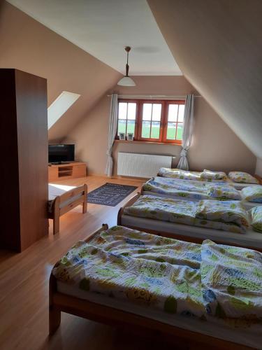 MieroszynoにあるDom wakacyjny Hortensja Jastrzębia Góraの屋根裏部屋のベッドルームにベッド2台が備わります。