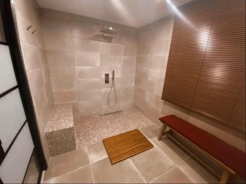 une salle de bain avec une douche avec un banc dedans dans l'établissement La perle rouge A Panazol, à Panazol