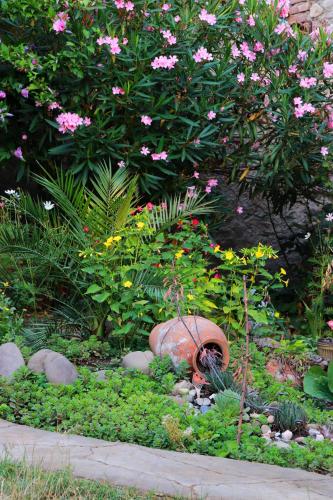a garden with a vase in the middle of flowers at GreenGate in Gurjaani