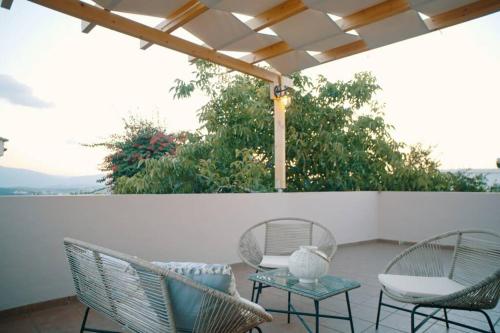 Dos sillas y una mesa en un patio. en Villa Apaggio, en Plaka