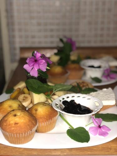 a plate with cupcakes and flowers on a table at Vila Isufaj in Vlorë