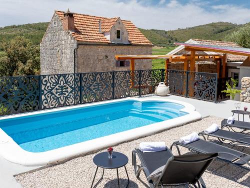 a swimming pool in front of a house at Stone House Prapatna in Smokvica