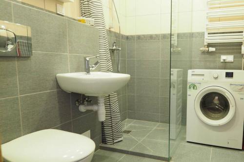 a bathroom with a sink and a washing machine at In the heart of Kaunas in Kaunas