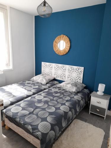 a blue bedroom with a bed and a mirror at LA CLOSERIE D'ISABAULT in Eu