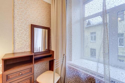 a room with a mirror and a dresser and a window at Welcome Home Apartments Liteyniy 10 in Saint Petersburg