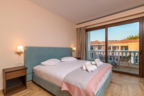 a bedroom with a bed and a large window at Zante Holidays Hotel in Kalamaki