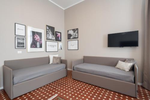 a living room with two beds and a flat screen tv at Hotel Palazzo Martinelli Dolfin in Venice