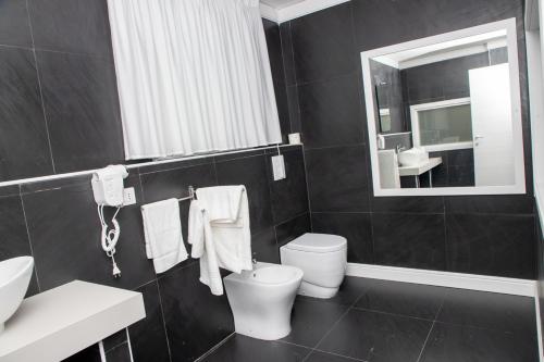 a bathroom with a toilet and a sink and a mirror at B&B Laura in Terzigno