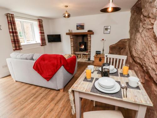 a living room with a table and a couch at The Old Mill Bake House in Ross on Wye