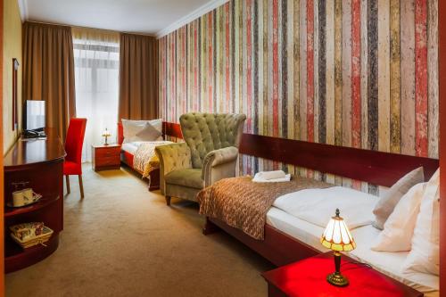 una camera d'albergo con letto e sedia di Hotel U Leva a Levoča