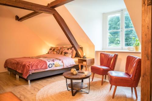 Schlafzimmer mit einem Bett, einem Tisch und Stühlen in der Unterkunft Klein Soestdijk in Veenhuizen
