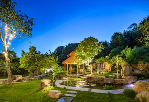 a home with a pond and a gazebo at Bai Dinh Riverside Resort & Spa in Ninh Binh